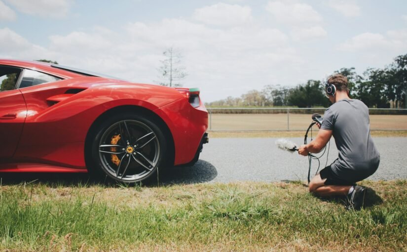 man behind car holding microphone measuring sound